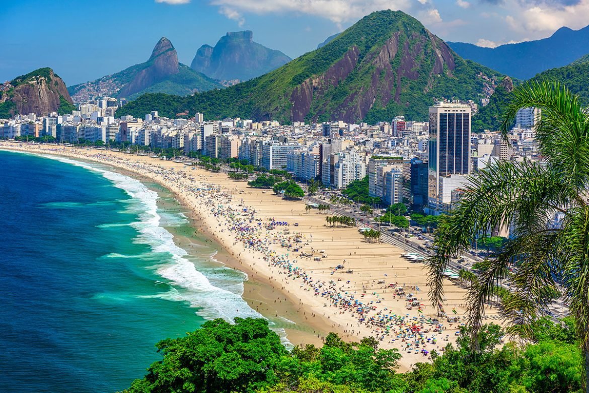 Colorful umbrellas on the beach with high-rise buildings in the background