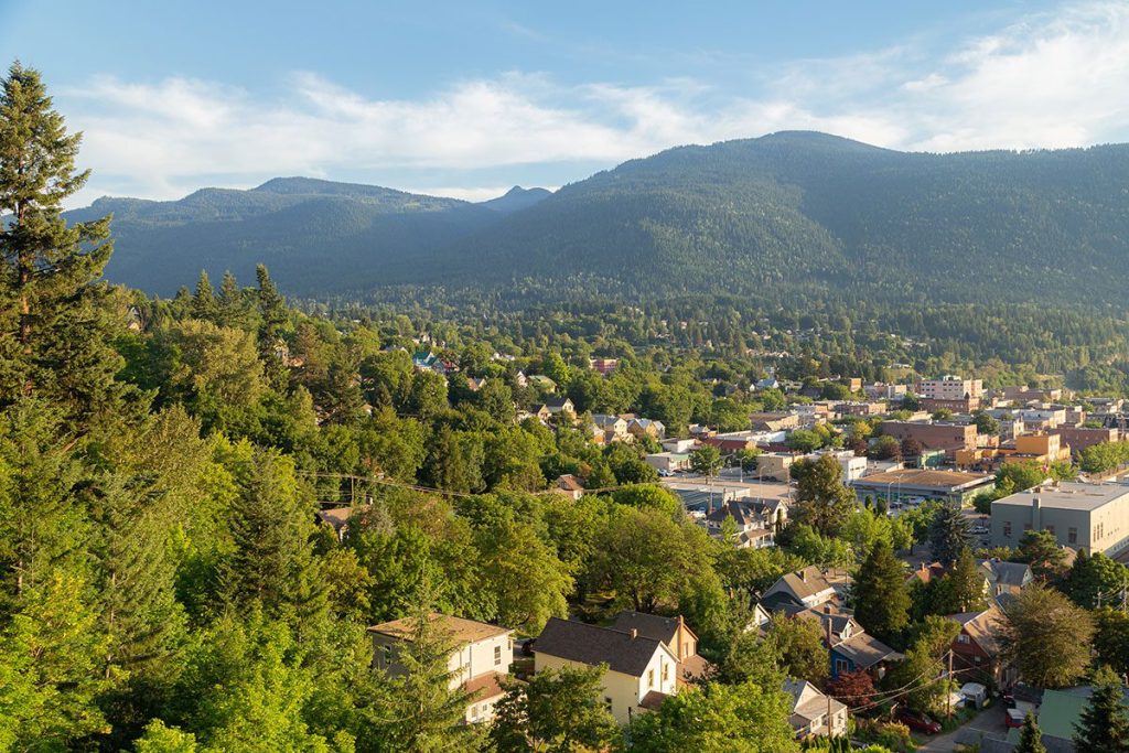 Aerial view of a small town surrounded by mountains and water.