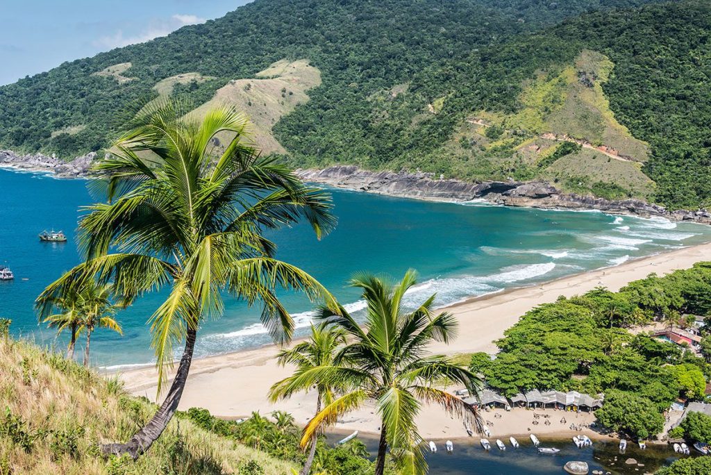 Aerial view of a tropical blue bay surrounded by lush greenery on Ilhabela Island, Brazil.