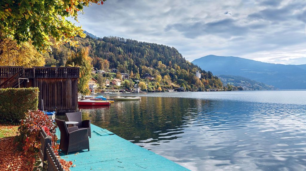 A beautiful view of the autumnal colors surrounding Millstatt am See, a charming town situated on the shore of Millstatt lake in Austria.