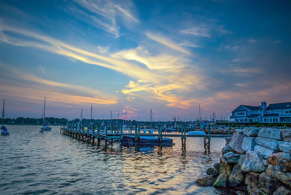 Summer sunset at Stonington CT waterfront with boats and calm water