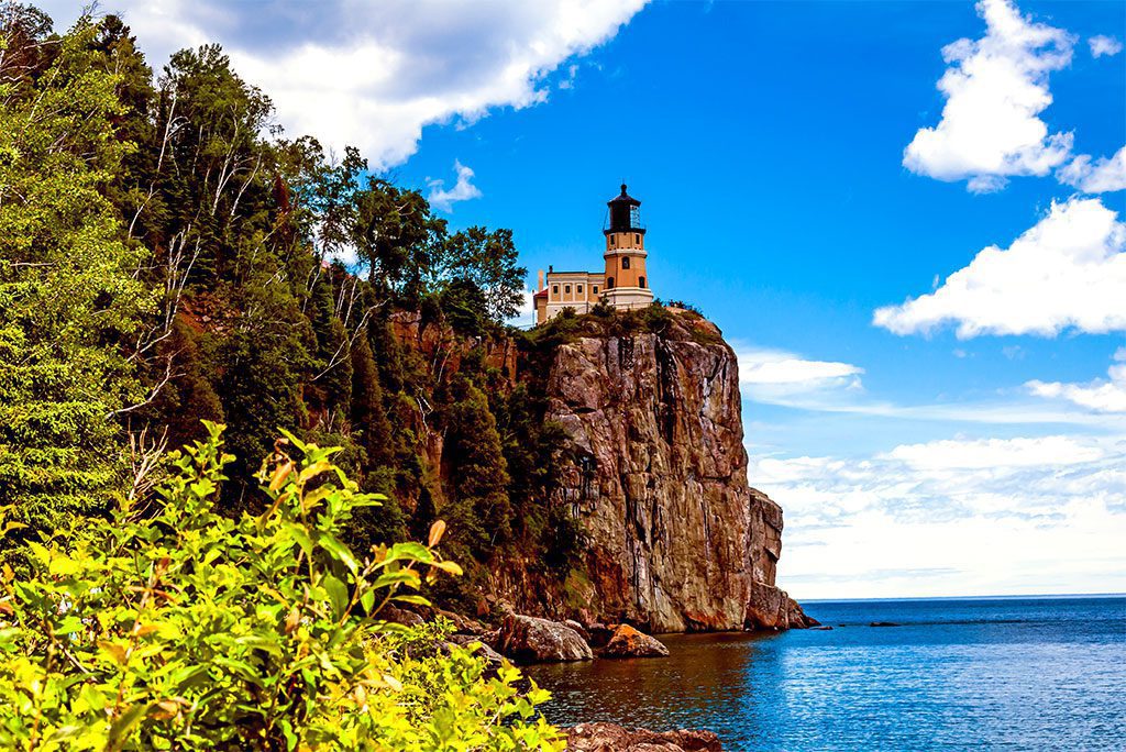 Split Rock Lighthouse with the blue waters of Lake Superior in the background.