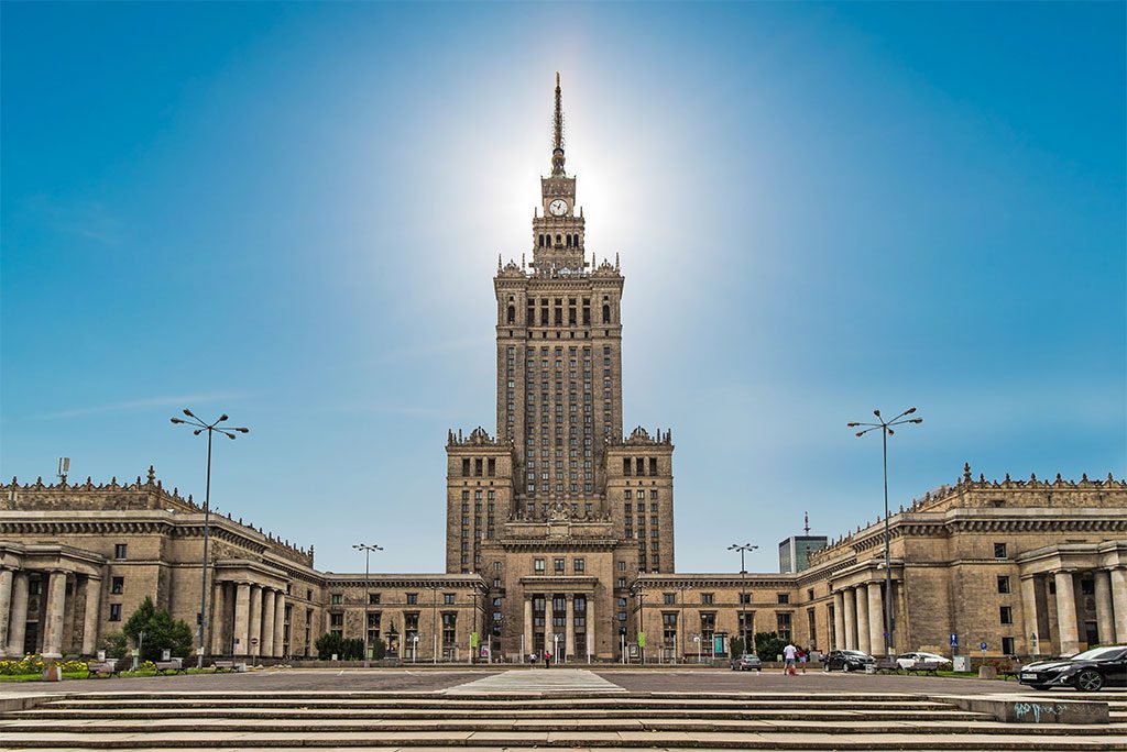 The iconic Palace of Culture and Science in Warsaw, Poland, against a clear blue sky.