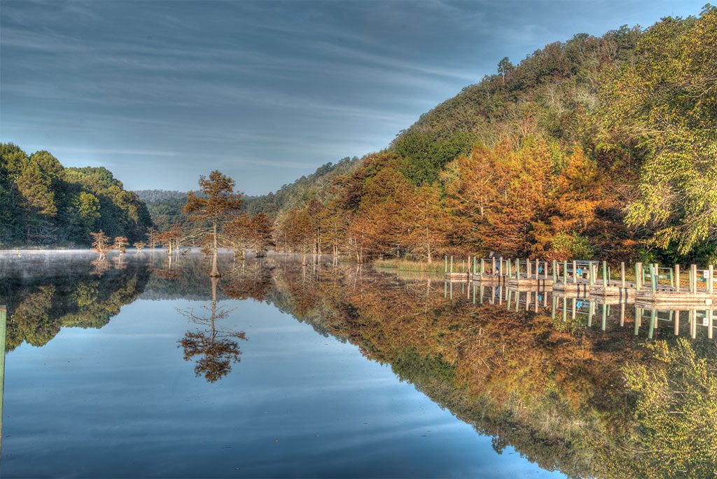 Beavers Bend State Park, Oklahoma, with a peaceful lake surrounded by trees in autumn.