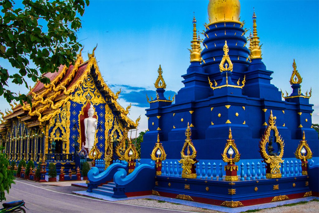 A stunning blue temple with a golden statue of Buddha