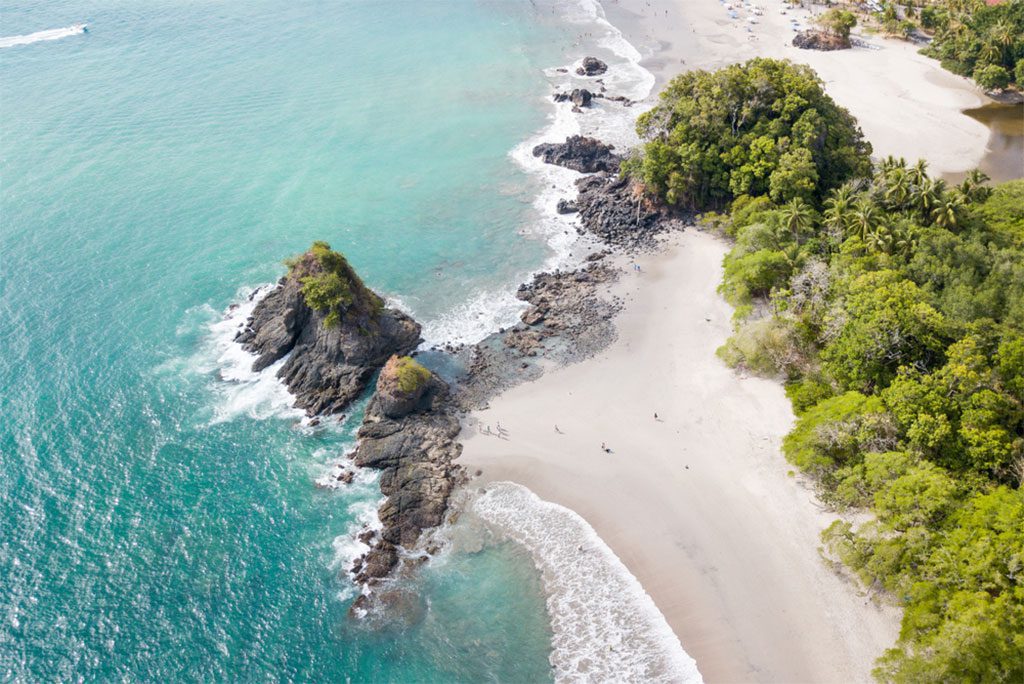 Manuel Antonio National Park in Costa Rica with lush tropical forest and beautiful beach.