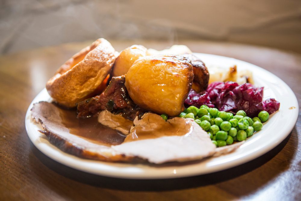 A mouthwatering Sunday roast dinner with roasted meat, vegetables, Yorkshire pudding, and gravy