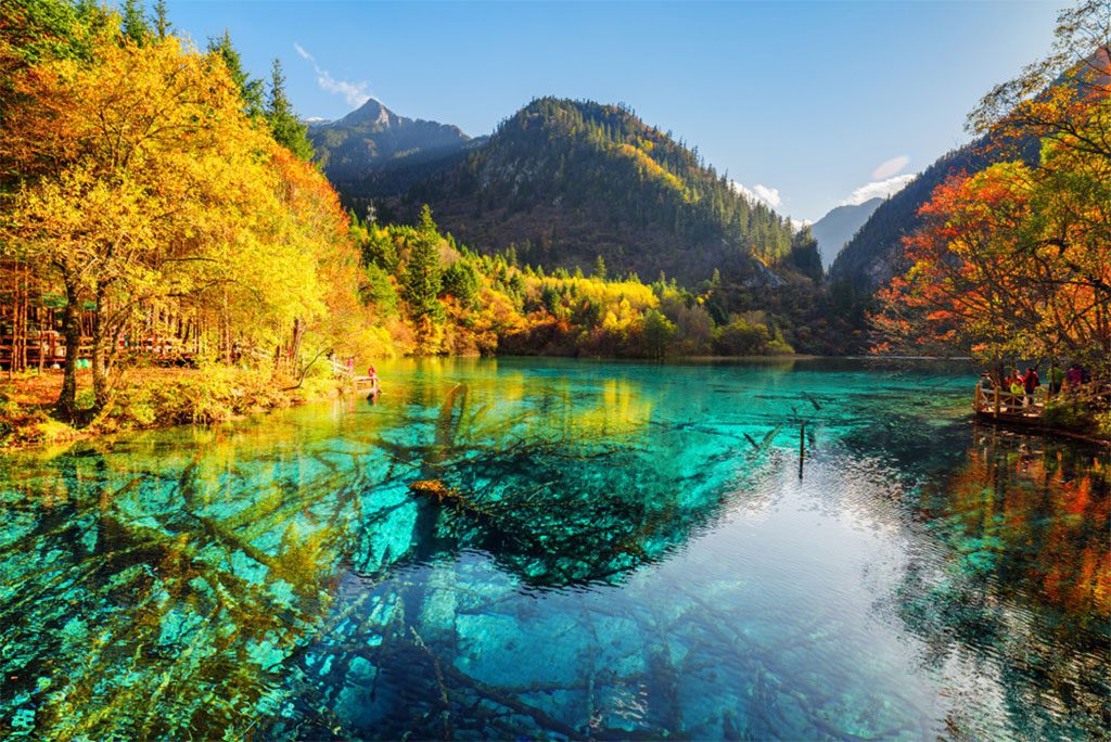 Scenic view of the Five Flower Lake among fall woods in Jiuzhaigou nature reserve.