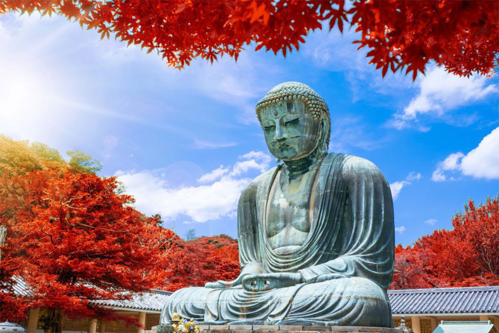 The Great Buddha of Kamakura surrounded by autumn leaves