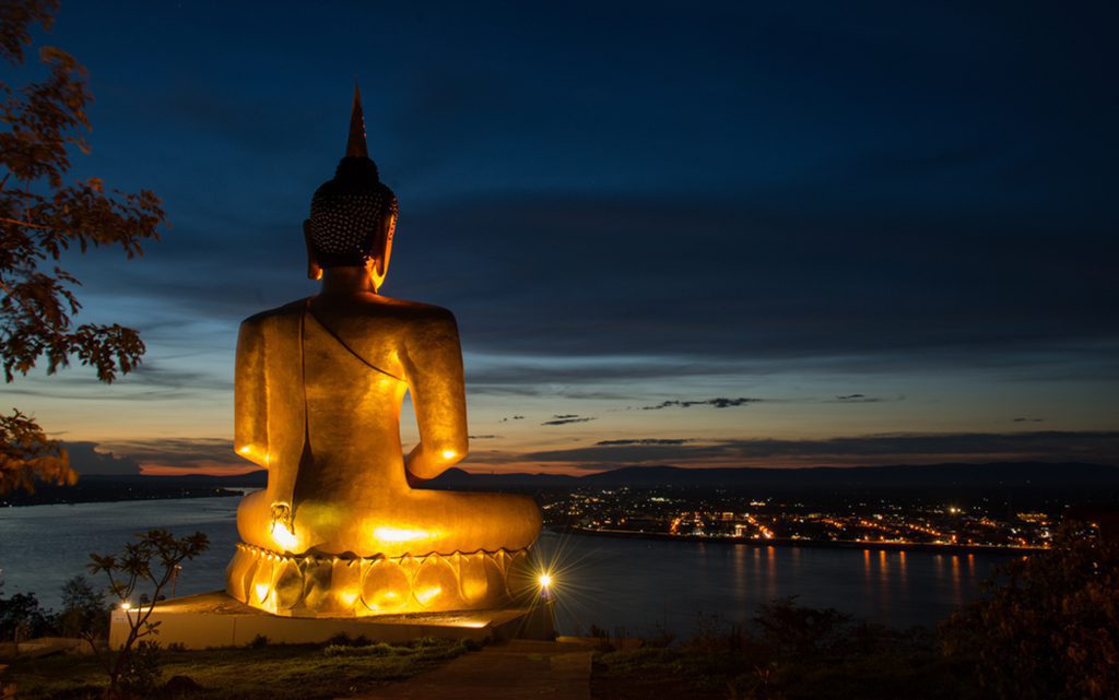 The majestic golden Buddha statue overlooking the Mekong River near Wat Phou Salao in Laos.