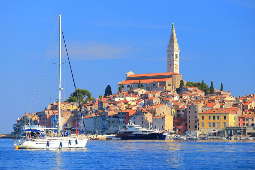 Tall sail boat entering the harbor of old Venetian town of Rovinj, Croatia