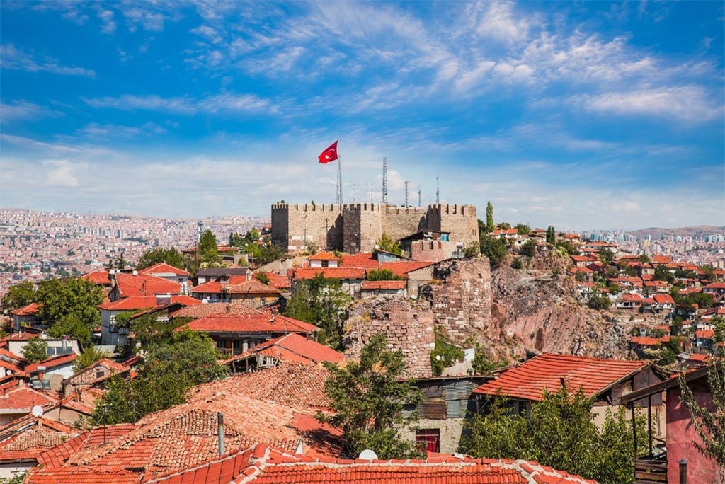 The historic old town of Ankara, Turkey with a mosque and colorful buildings lining the street.