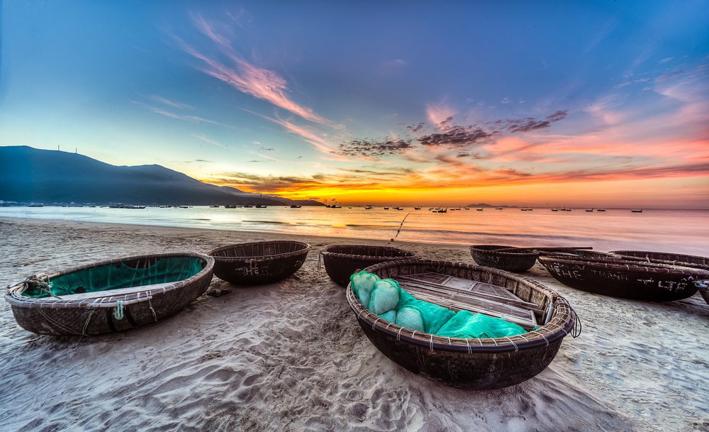My Khe beach at sunrise with fishing boats in Danang, Vietnam.