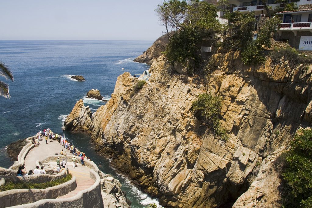 A person cliff diving into the water in Acapulco, Mexico