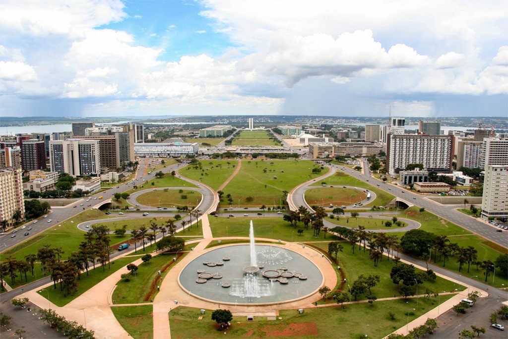 Brasilia skyline with modern architecture buildings and reflecting pool in the foreground.
