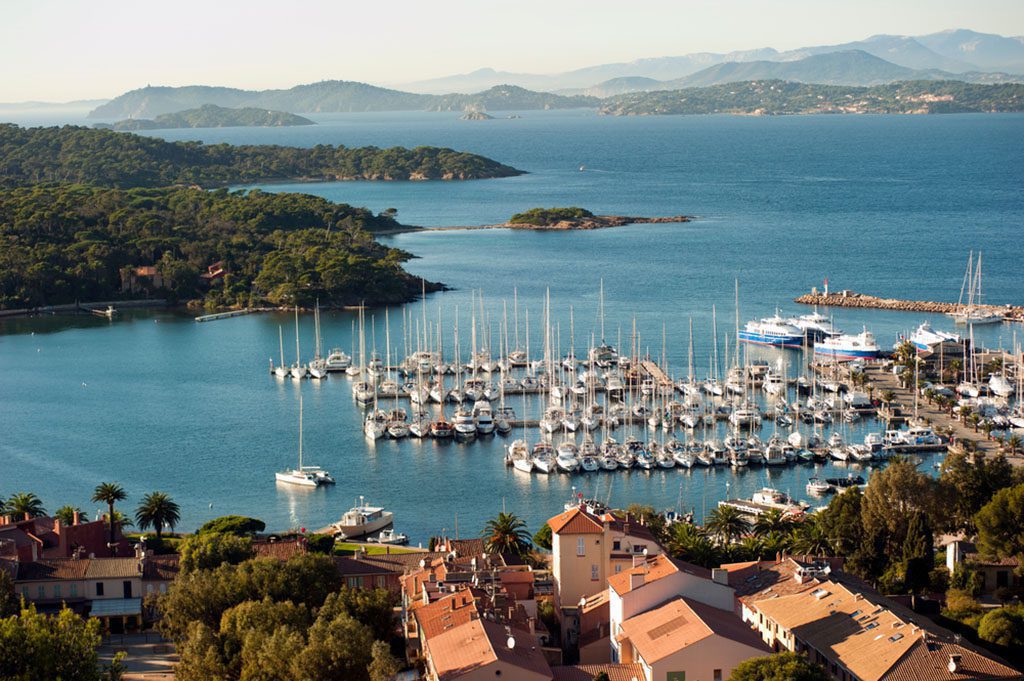Scenic view of Porquerolles Port Cros National Park with crystal clear blue waters and lush greenery in Hyeres, France.
