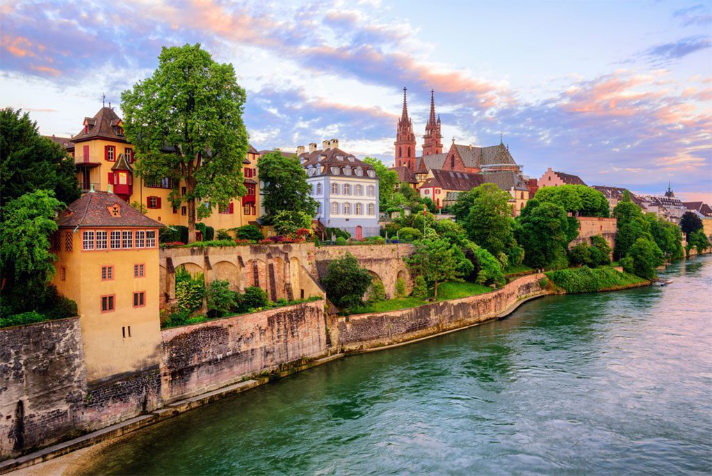 Old Town of Basel with Munster cathedral and Rhine river at sunset