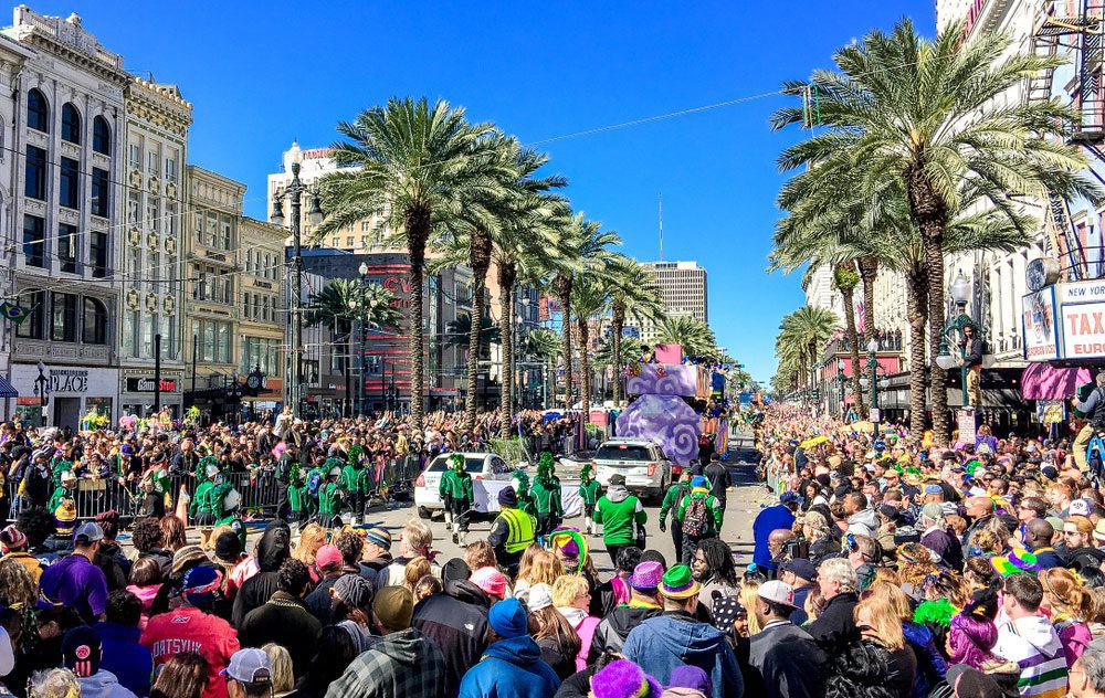 Crowd of tourists and locals celebrating Mardi Gras along city streets in New Orleans