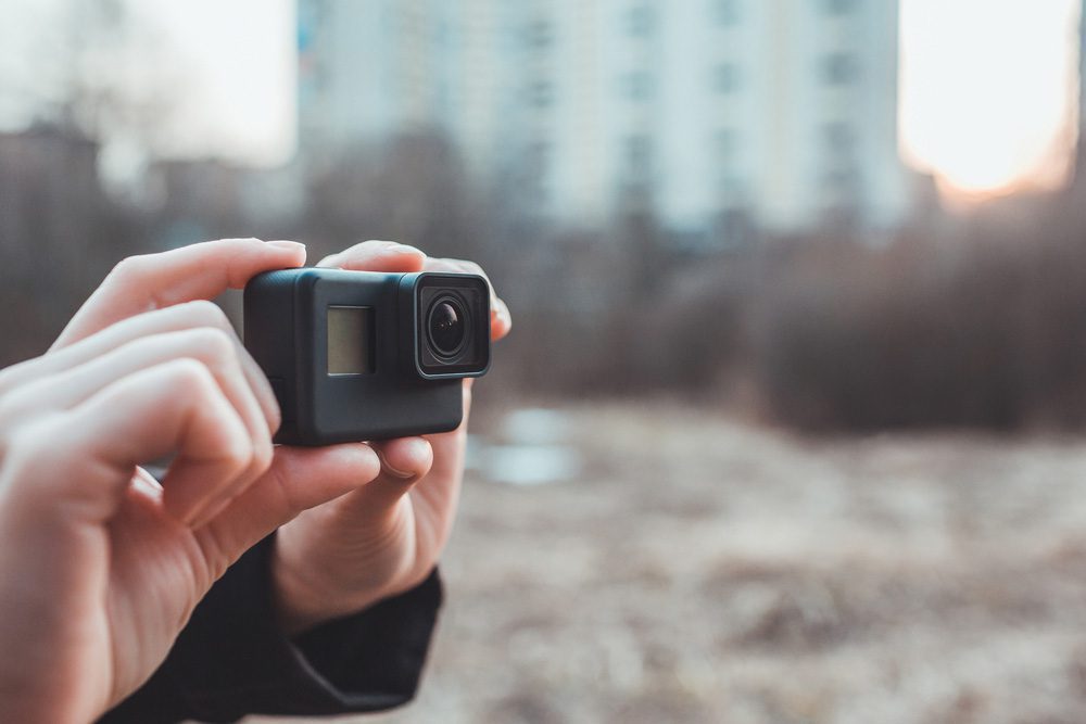 Hands gripping a compact action camera