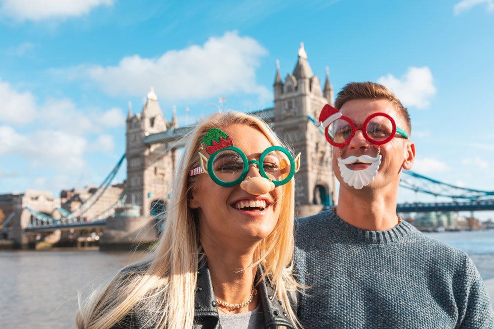 Best Christmas Vacations for Couples: Happy couple with Christmas glasses in London