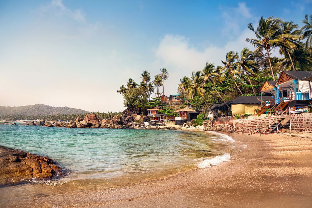 Palolem Beach, One of the 15 Best Places to Visit near Goa, Featuring Sunny Day and Cottages by the Lagoon